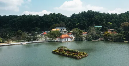 The sacred Temple of the Tooth in Kandy against a backdrop of green hills.